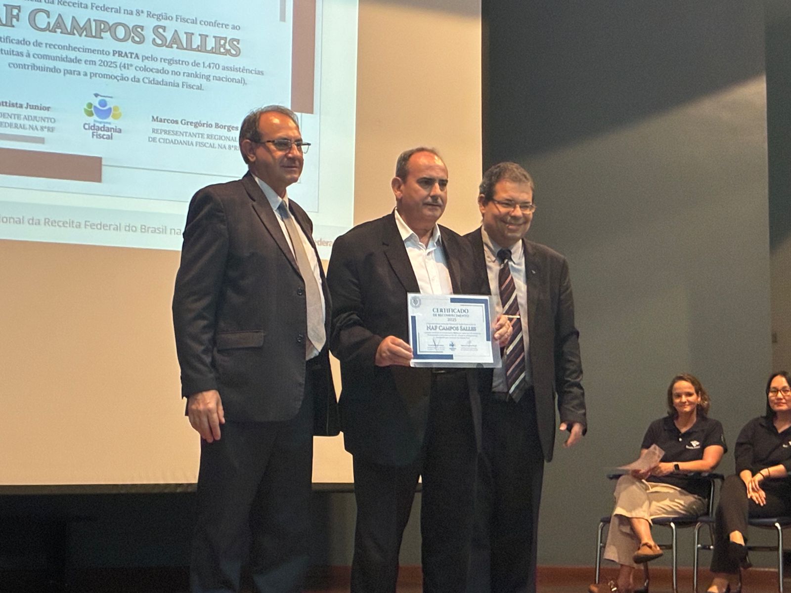 Professor Manuel Leitão recebendo o certificado PRATA da Receita Federal pelo NAF Campos Salles em reconhecimento às 1.470 assistências fiscais gratuitas