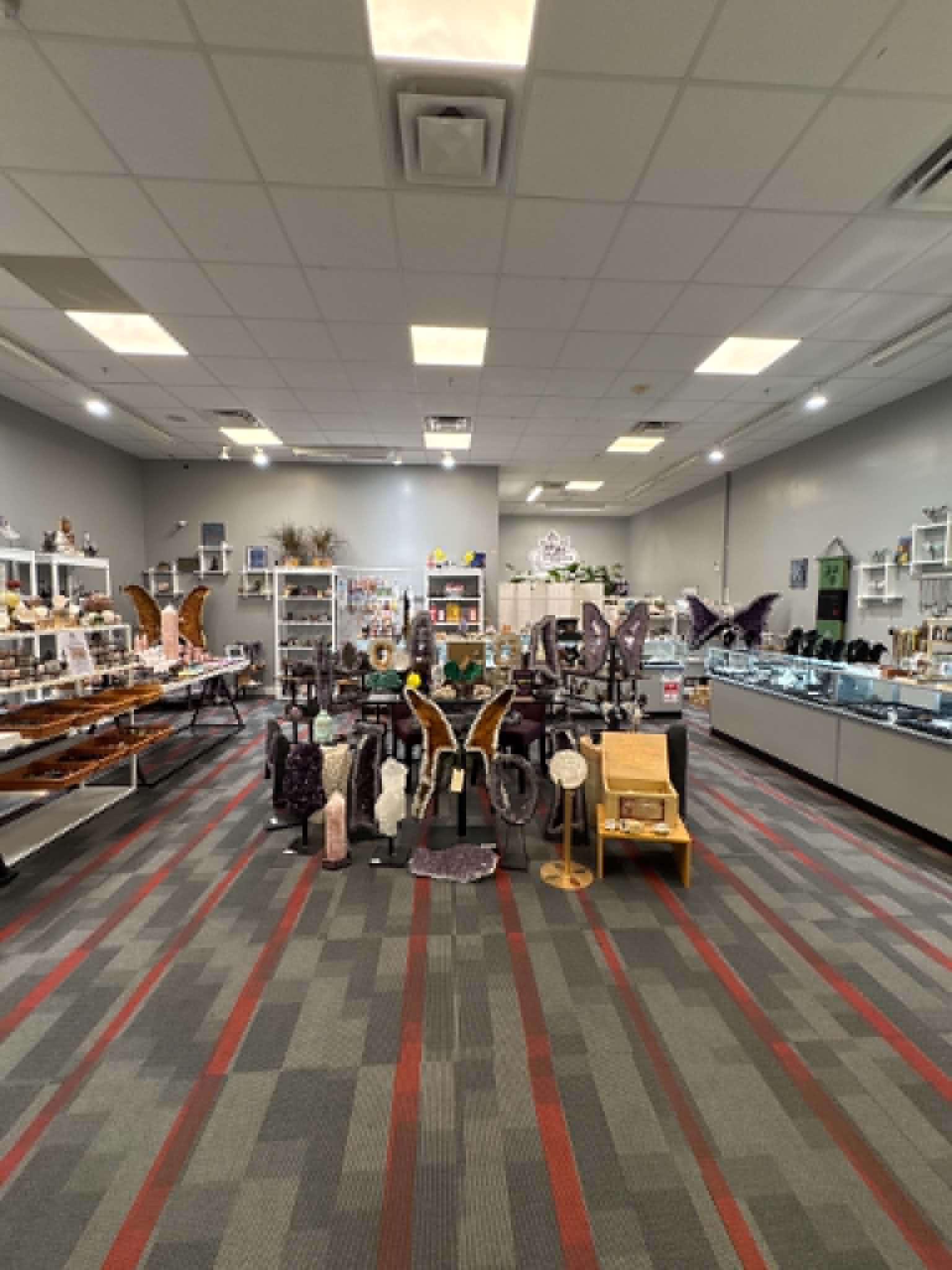 Dragon Traditions crystal shop interior at Oakland Mall in Troy, Michigan showing displays of healing crystals, amethyst geodes, and gemstone jewelry